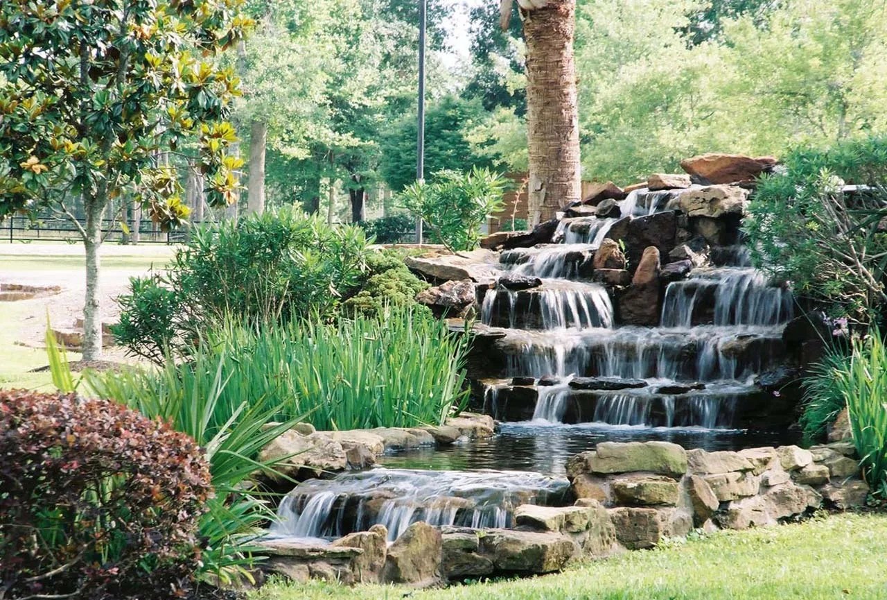 Custom stone waterfall and water feature landscaping Magnolia TX — New Yards Landscaping